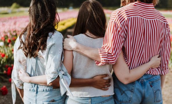 Foto de tres personas abrazadas