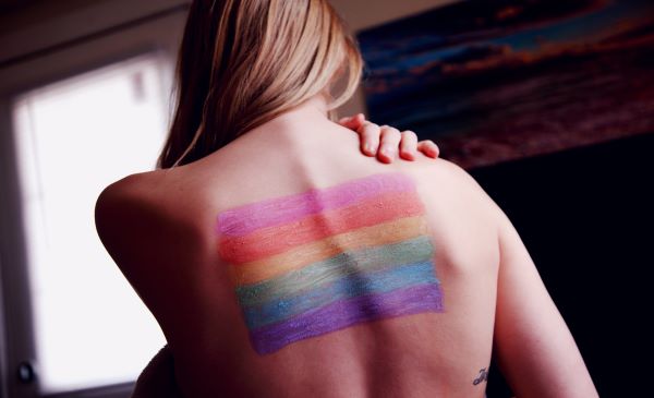 Persona con una bandera LGBT en la espalda