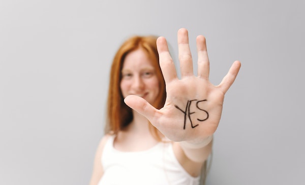 Persona con un 'yes' en la mano sobre el consentimiento