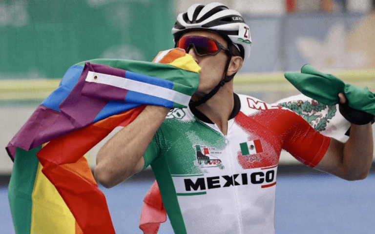 Persona practicando ciclismo con una bandera LGBT