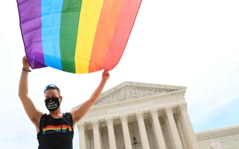 Una persona con la bandera LGBT frente a la Corte de Estados Unidos