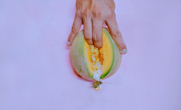 Persona con sus dedos sobre un melón