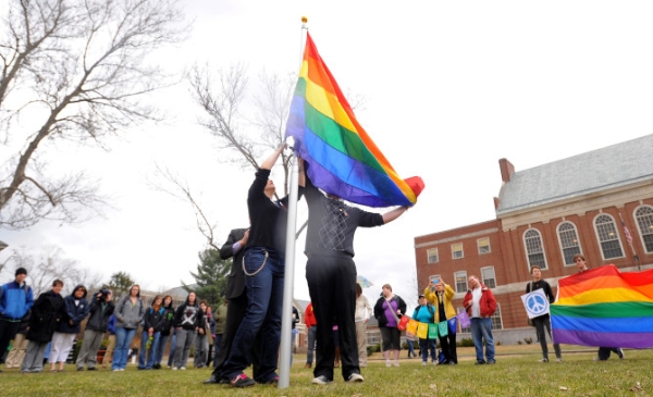 personas izando una bandera LGBT