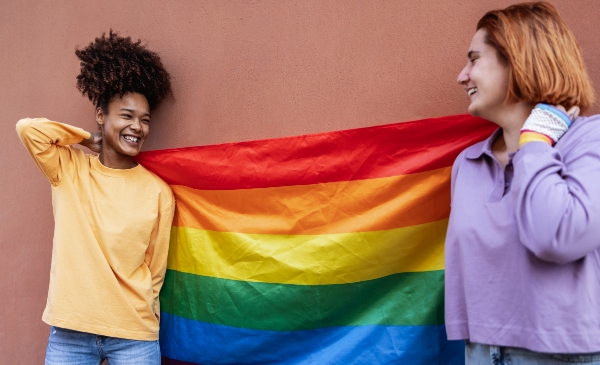 dos chicas agarrando las bandera LGBT