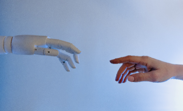 Una mano humana tocando una mano robotica