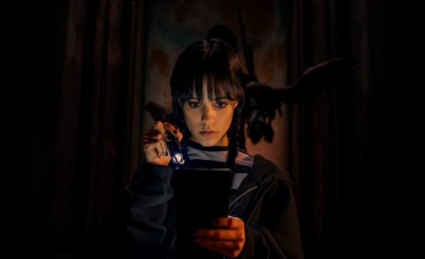 Merlina Addams mirando su celular