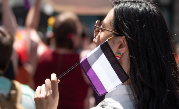 Persona con la bandera asexual