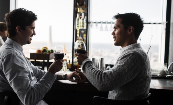 hombres tomando una copa de vino
