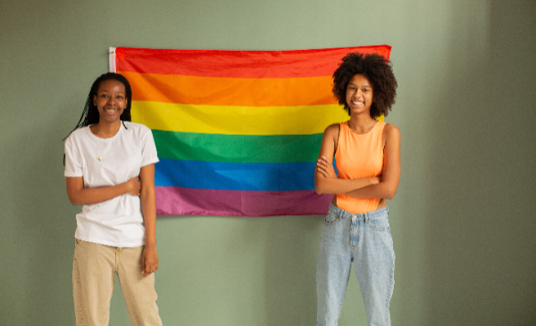 Dos personas frente a la bandera LGBT
