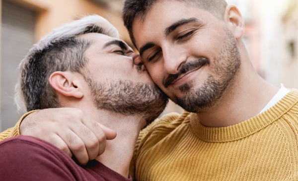 un chico dandole un beso a otro en el cachete