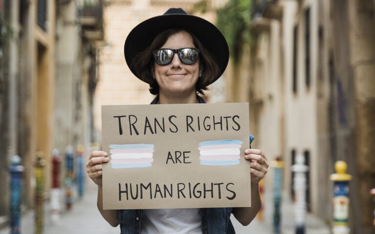 Persona con un cartel de derechos trans