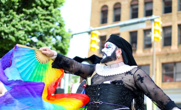 Drag king hondeando una bandera LGBT