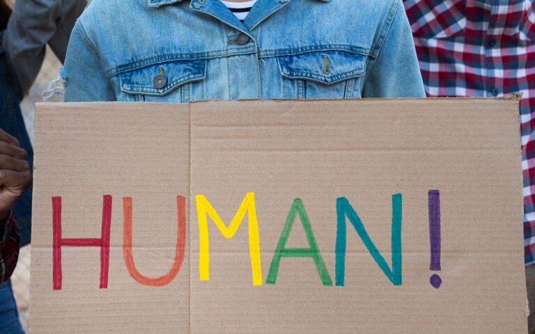 Hombre asexual sosteniendo un cartel de Human
