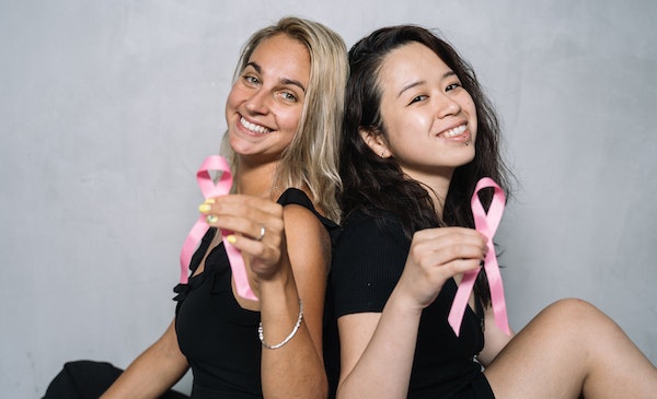 Dos mujeres con el símbolo del cáncer de mama